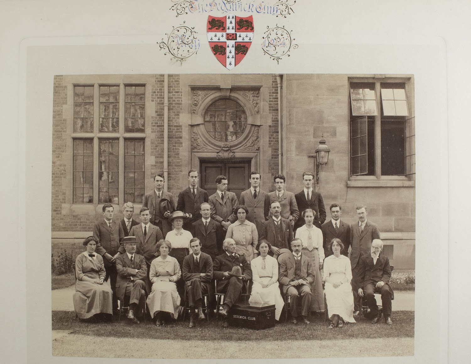 A formal photograph of students outside a university building. There are 18 men and 7 women.
