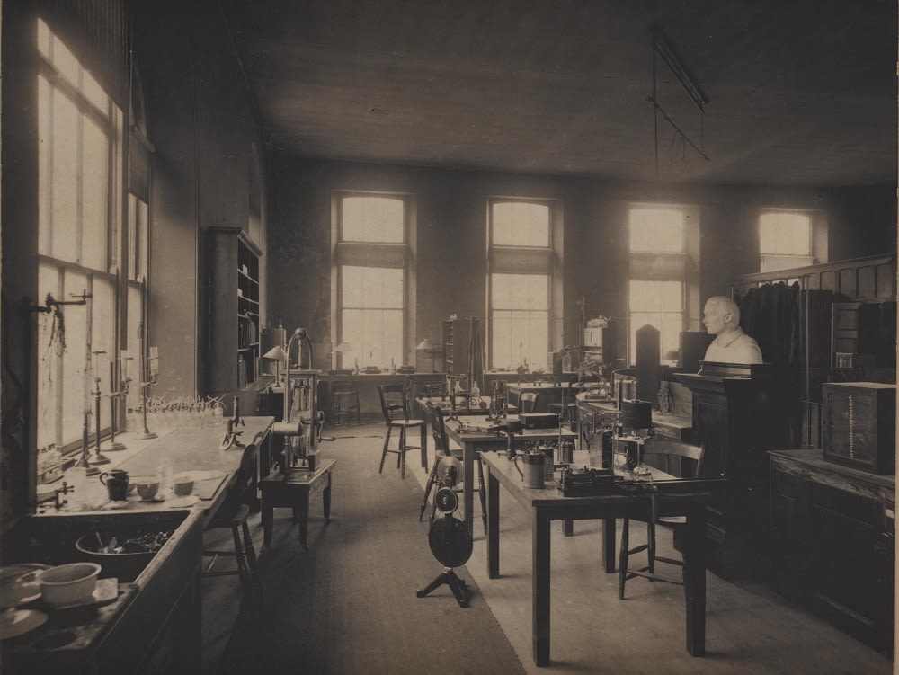 photograph of a science laboratory with windows, sink, desks and equipment. There is a bust of Francis Balfour in the room.